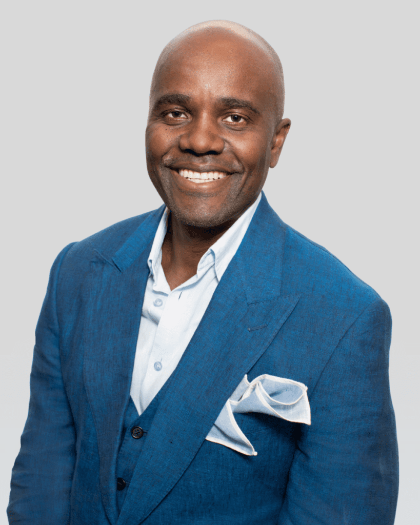 Smiling Wes Hall in blue suit and white pocket square