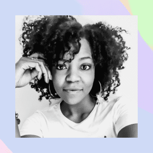 Black and white photo of a Black woman with beautiful curly hair smiling at the camera.