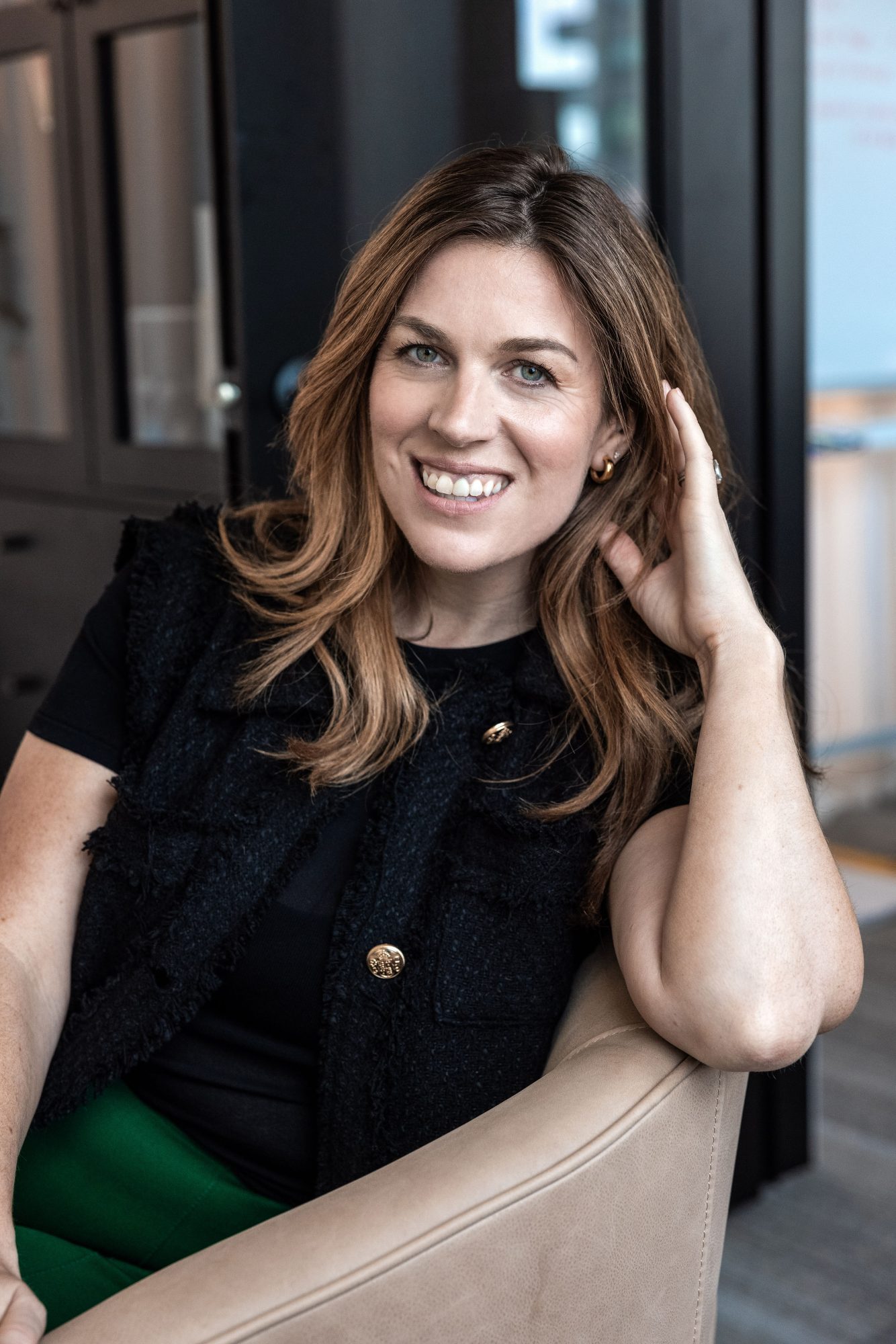 Joanna Griffiths smiling and leaning against the back of a couch