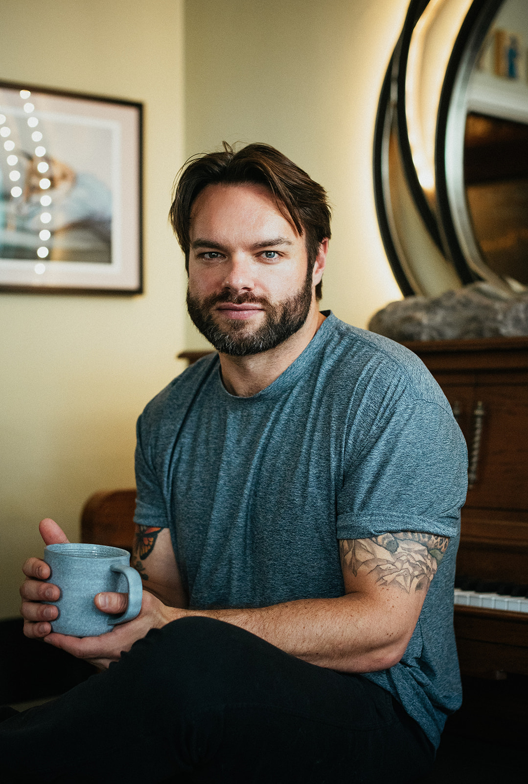 Matthew McLaughlin seated wearing a green t-shirt with a coffee