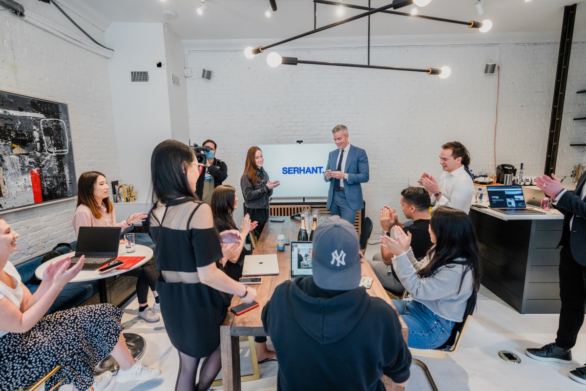 Group of energized sales people gathered in a brightly lit room