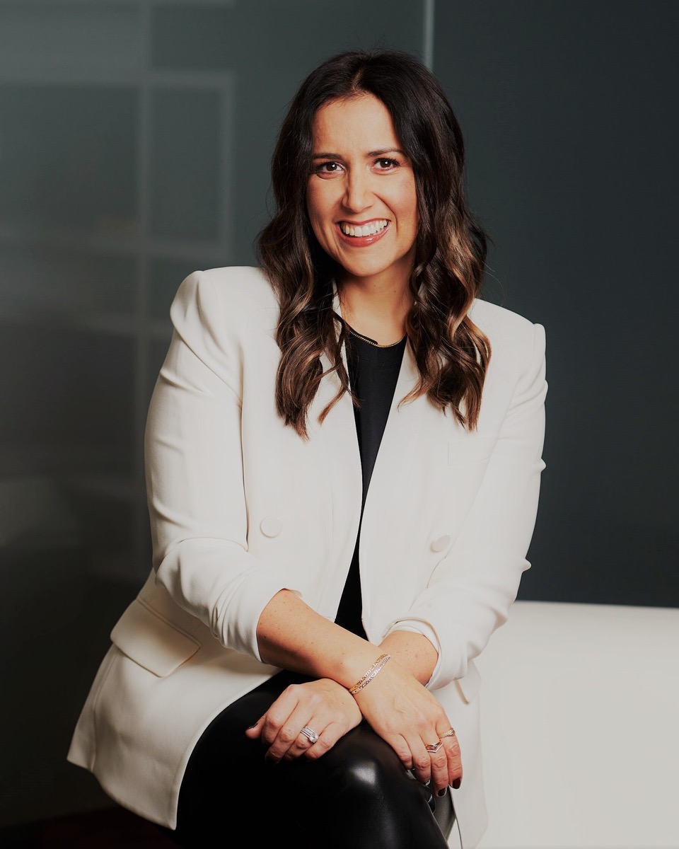Woman in white blazer sitting on white couch
