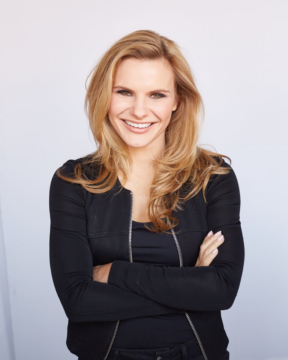 Michele Romanow in black jacket folding arms